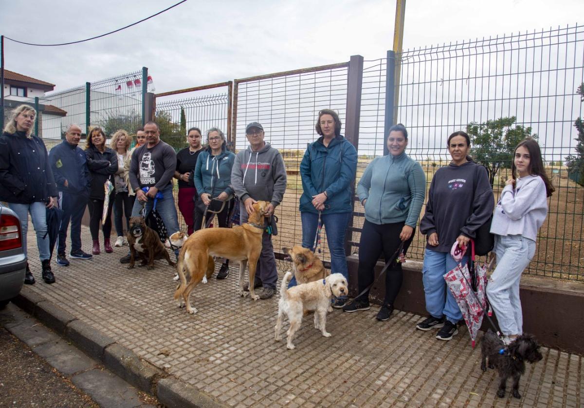 Familias con perros en la puerta del parque canino clausurado.