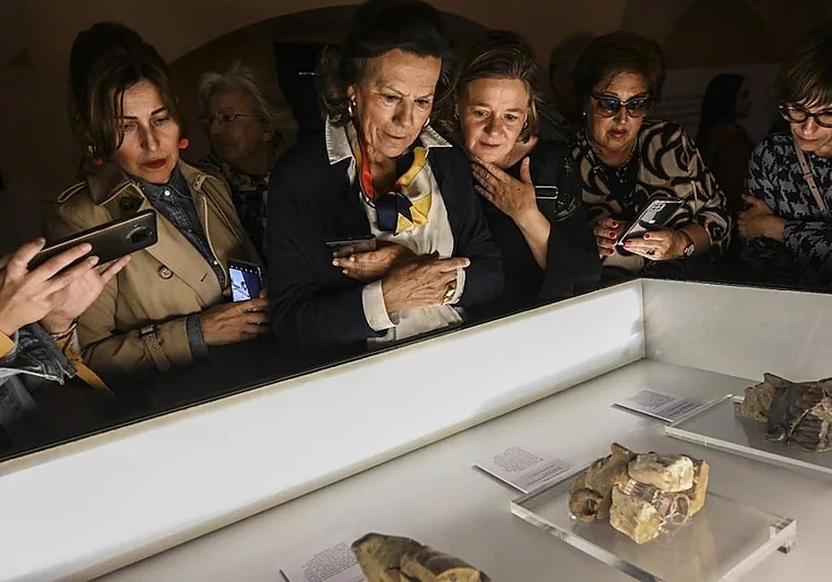 Visitantes observan los rostros del Turuñuelo durante la exposición en el Arqueológico Provincial de Badajoz.