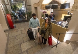 Viajeros en la recepción del hotel NH Palacio de Oquendo, en Cáceres.