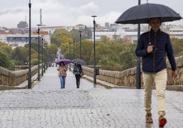 Varias personas cruzan el Puente Romano de Mérida, hoy.