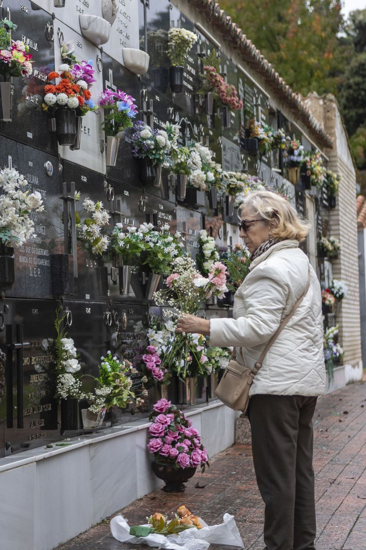 Una mujer colocaba flores este jueves en un nicho del cementerio municipal de Cáceres.