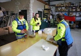 Voluntarios de DYA clasifican los primeros paquetes de ayuda que están llegando a las naves de CIFE este viernes en Cáceres.