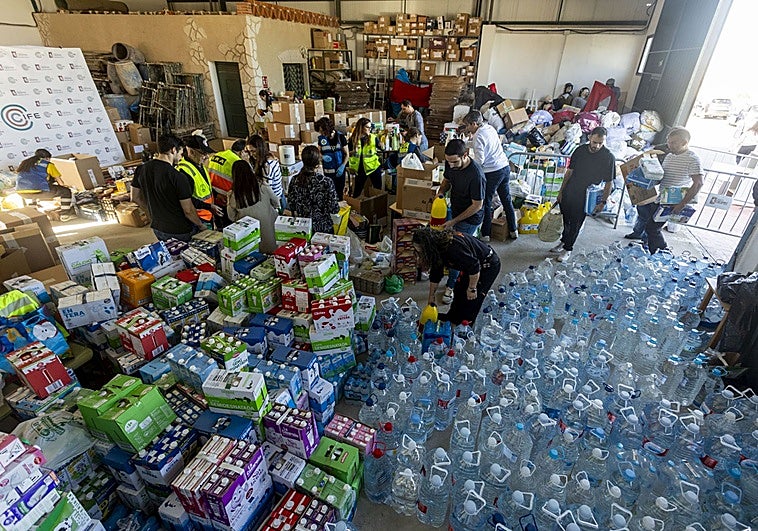 La nave habilitada por el Ayuntamiento de Cáceres llena de productos y voluntarios intentando organizarlos.