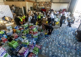 La nave habilitada por el Ayuntamiento de Cáceres llena de productos y voluntarios intentando organizarlos.