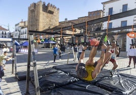 Dos de los participantes superando los obstáculos en la Plaza Mayor de Cáceres.