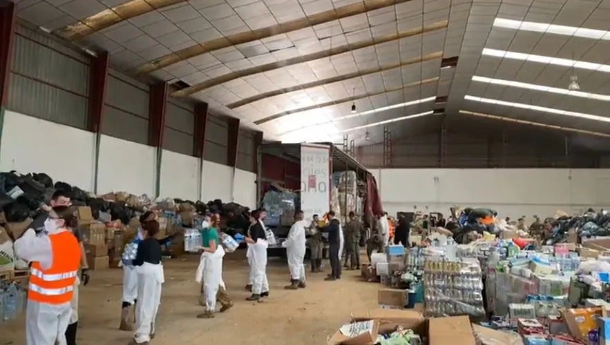 Una cadena humana de voluntarios y efectivos del Ejército descargan el tráiler con más de 25.000 kilos de ayuda procedente de Alconchel y otros municipios de La Raya.