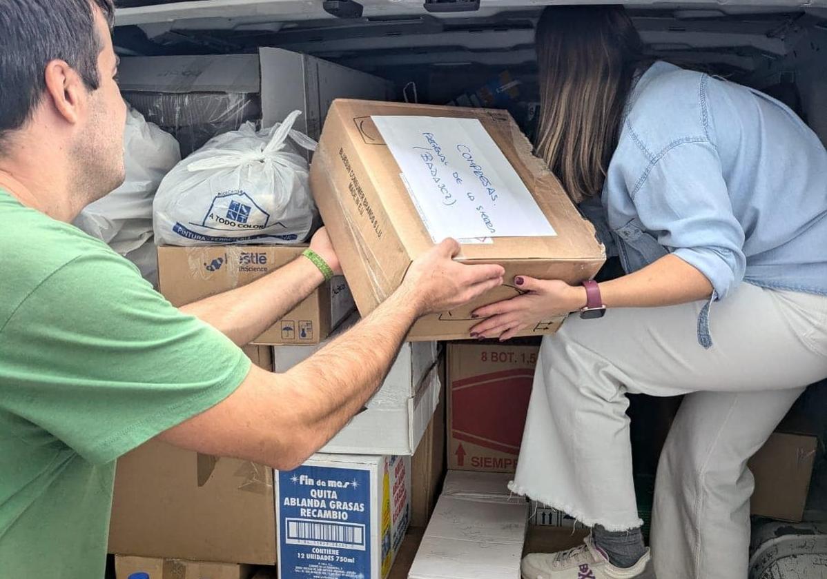 Jóvenes frexnenses llenando un coche con material de limpieza para llevar a Valencia.