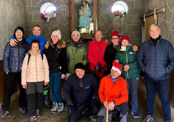 Los senderistas posan en el refugio delante del belén.