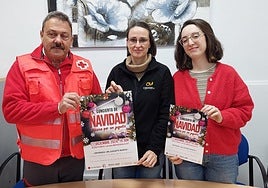Los organizadores posan con el cartel del concierto que tendrá lugar el día 27.