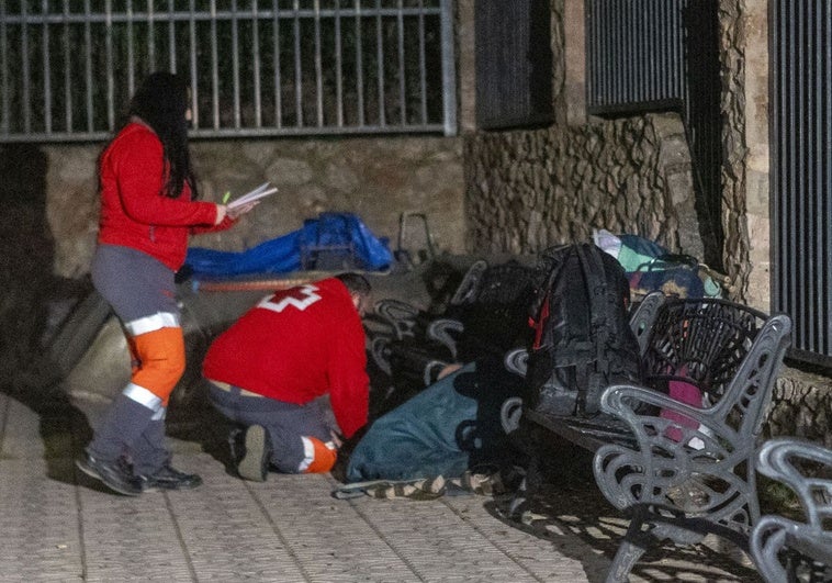 Dos voluntarios atienden a una persona sin hogar en la primera jornada del protocolo 'Ola de frío'.