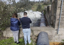 Dos personas presencian un desembalse en el Guadiloba.