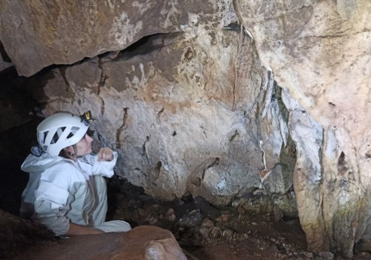 Una visitante observa las manos impresas en la cueva de Maltravieso en una de las últimas visitas programadas al interior.