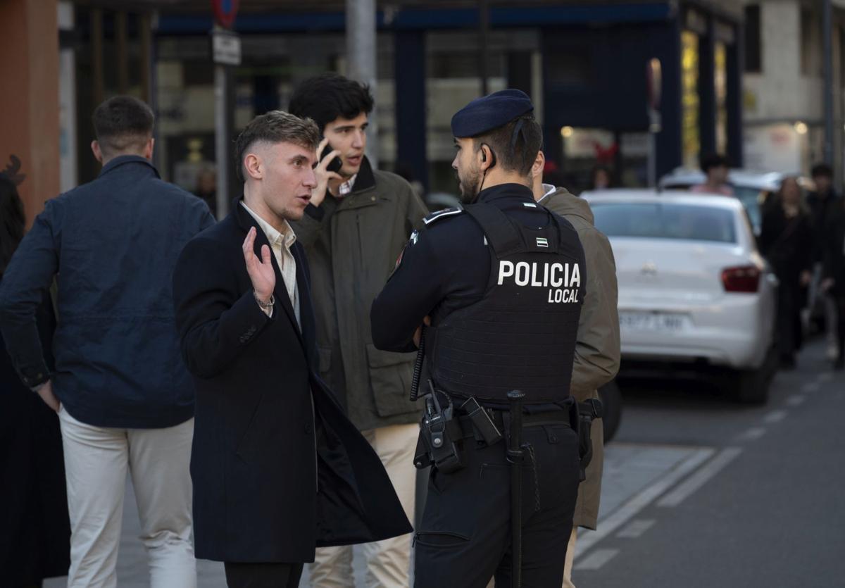 Un agente de la Policía Local en la plaza de los Alféreces atiende a varios ciudadanos el día de la Nochebuena.