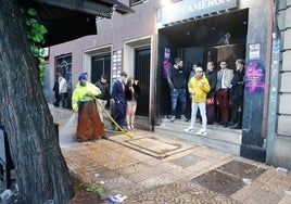 Un operario del servicio de limpieza baldea en la avenida de España ante la discoteca Cameron en la mañana de este Año Nuevo.