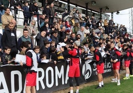 Los jugadores del Mérida firman autógrafos a los aficionados que acudieron al estadio Romano en el entrenamiento de puertas abiertas.