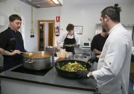 Nico Vázquez, a la izquierda, termina el guiso que preparó ayer en el comedor social.