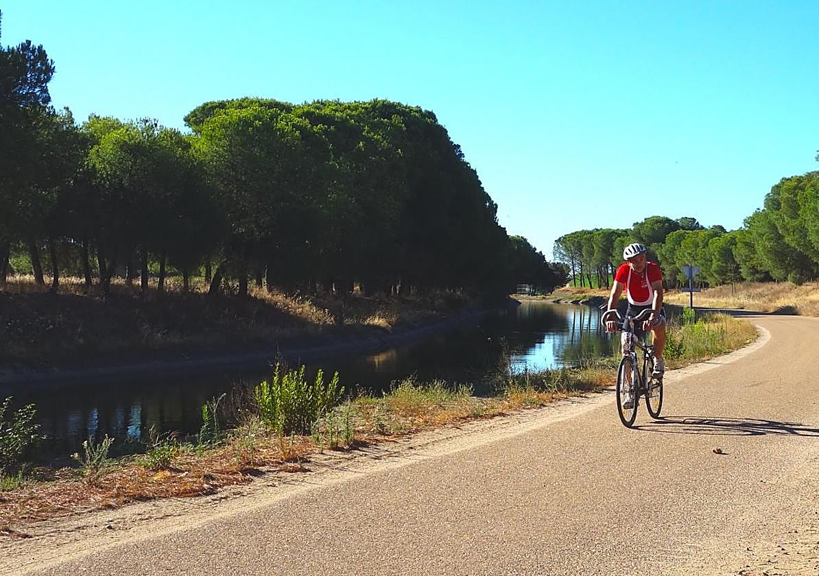 Un ciclista pedalea junto al canal de Orellana.