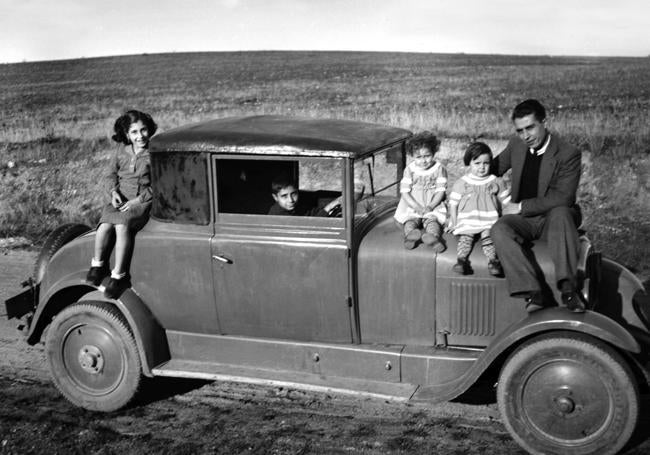 Familia posando sobre su coche.