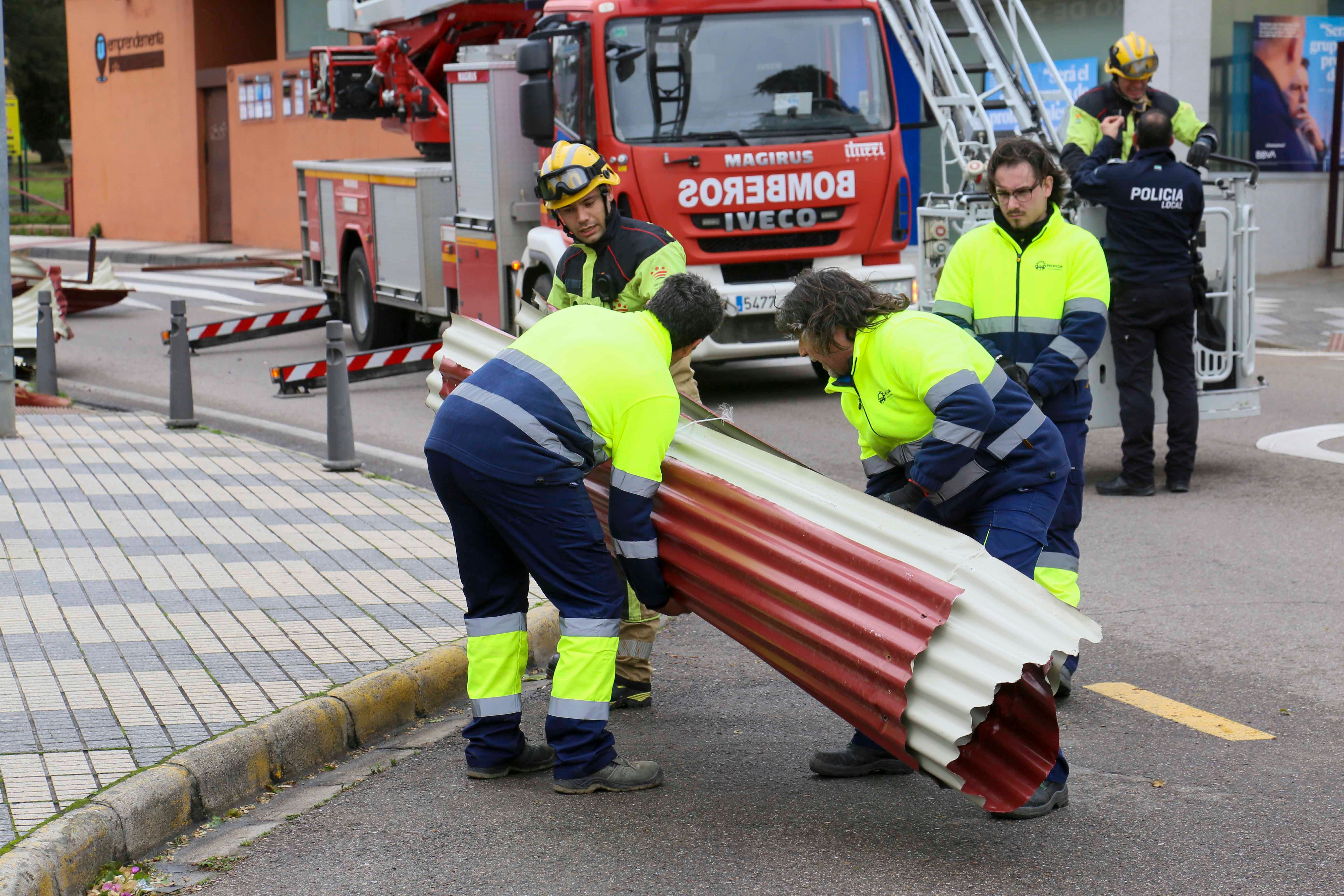 Bomberos del parque de Mérida y trabajadores del Ayuntamiento han retirado los restos de la cubierta del centro de Salud que ha volado.