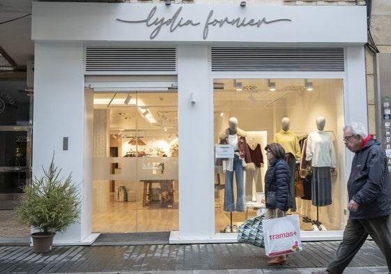 Rosario Fernández pasa con bolsas por la puerta de Lydia Fornier, una tienda de emprendedores locales.