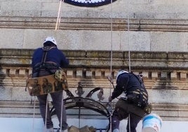 Los operarios trabajan sobre la fachada para retirar la corona del escudo.