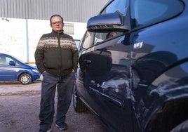 Juan Iglesias, en un taller de Charca Musia, con su coche tras el percance sufrido.