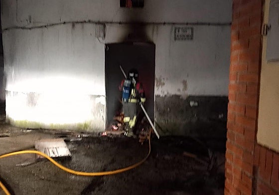 Un bombero en la puerta de la vivienda afectada por el fuego en el que ha muerto un niño de 10 años y una mujer de 75.