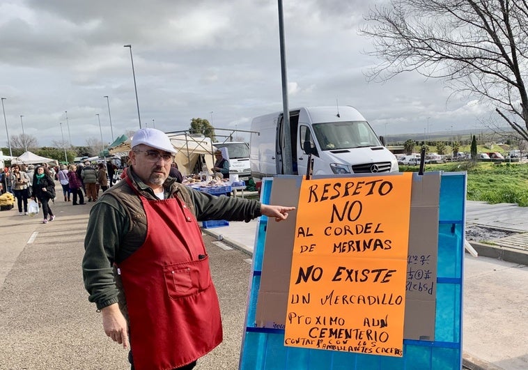 Juan Carlos Caldito junto al cartel que presidía este miércoles una de las entradas al mercadillo.