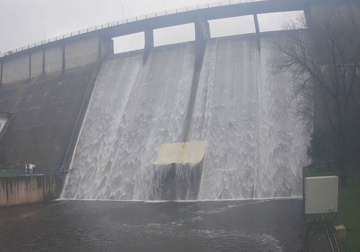 Presa de Villar del Rey, rebosando agua a las 12.10 horas de este lunes.