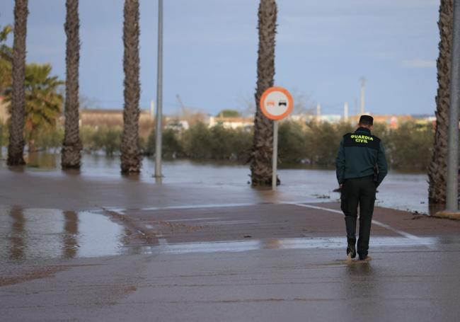 Un guardia civil vigila la crecida del río Ortiga en Medellín.