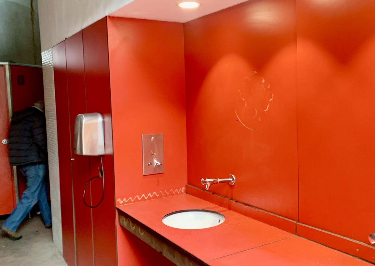 Imagen secundaria 1 - La zona de los urinarios, afectada. La de los lavabos sin espejo, por haber desaparecido, una parte del mobiliario deteriorada y el servicio sin tapadera.