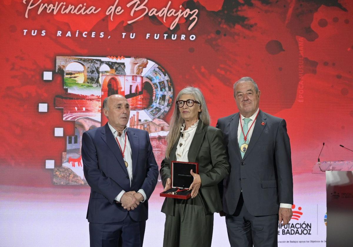 La madre de Carolina Yuste, rodeada por Ricardo Leal y Javier del Pueyo, en la entrega de medallas de la provincia de Badajoz que otorga la Diputación.