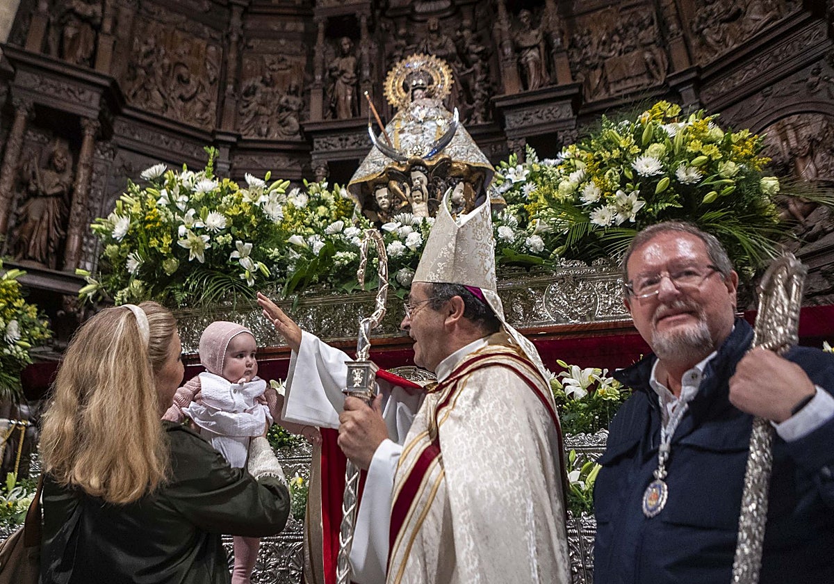 El obispo, Jesús Pulido, imparte la bendición a uno de los 86 niños que este miércoles han sido presentados ante la patrona de Cáceres, que ha lucido el manto número 8.