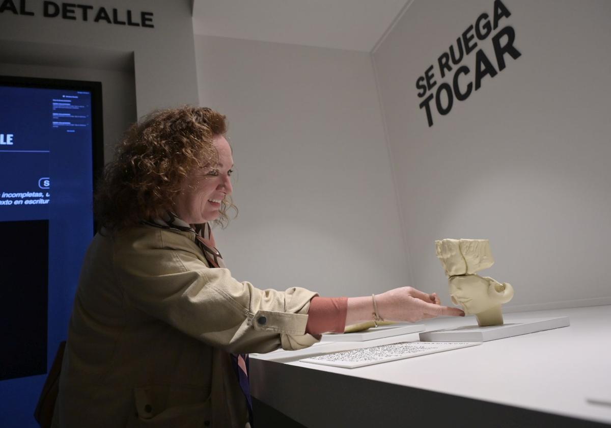 Una visitante del museo toca una representación de un rostro del Turuñuelo.