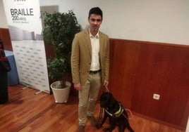Román junto a Troya, su perra guía.