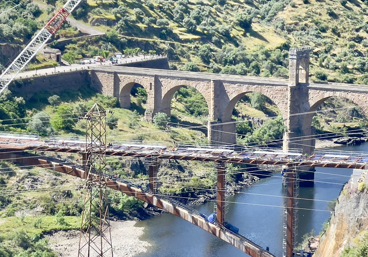 El viaducto en obras en Alcántara se alza entre el puente romano y la presa.