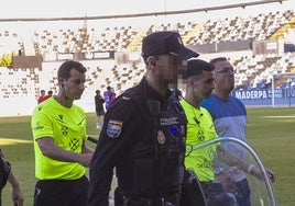 Los colegiados, escoltados por la Policía a su salida del césped del Nuevo Vivero el pasado domingo.