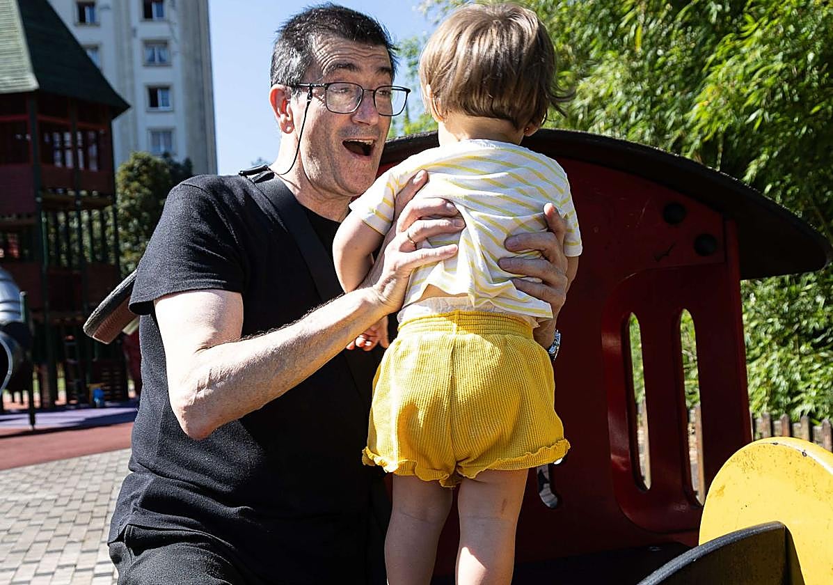Niños con abuelos jugando en un parque infantil.