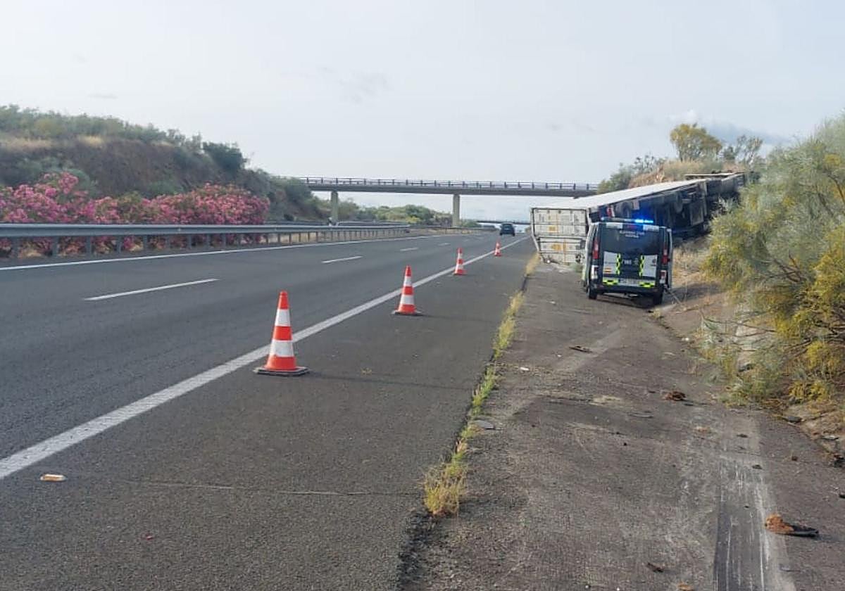 El camión se ha salido por el margen derecho de la vía y ha acabado volcado en el arcén.