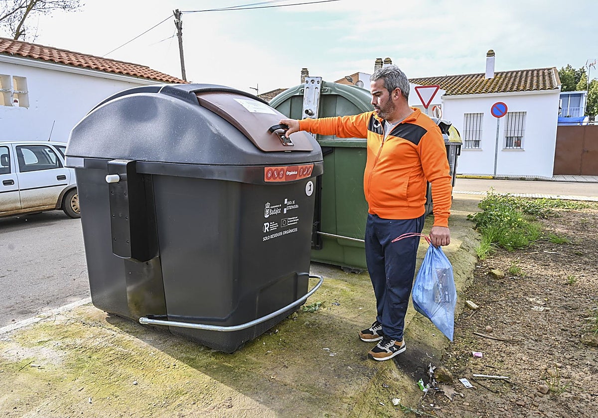 Un pacense deposita una bolsa de basura en un contenedor.
