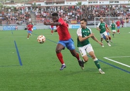 Iván Martínez defiende a Dago en el Estepona-Cacereño del playoff de ascenso.