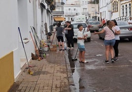 Los vecinos han sacado cepillos y cubos para limpiar los restos de la tormenta de agua y granizo en Los Santos de Maimona.