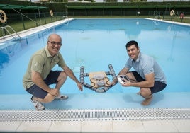 El alumno Manuel Medina con su trabajo de fin de grado junto a su profesor José Luis Herrero mostrando el salvavidas de control remoto.