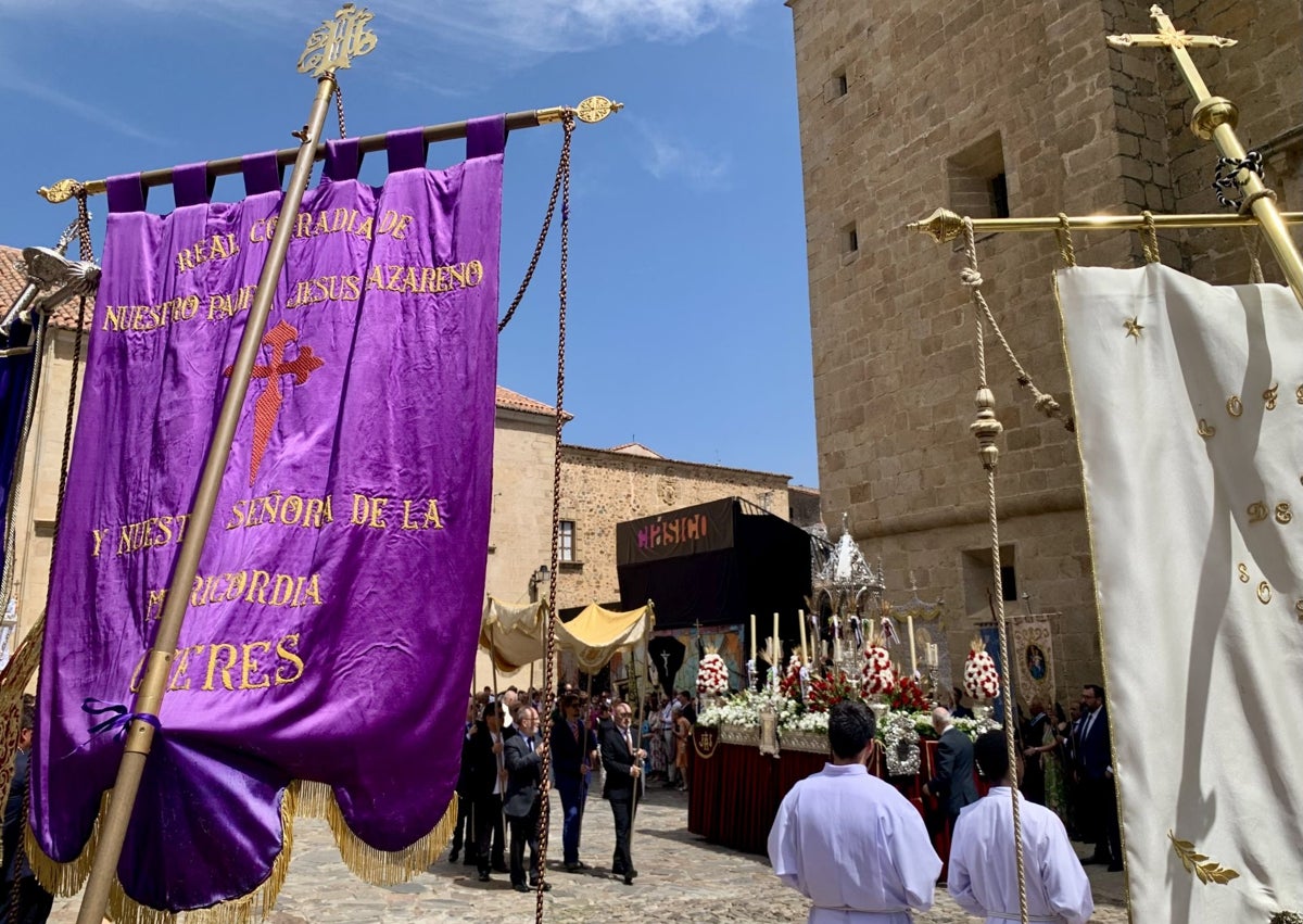 Imagen secundaria 1 - Los pequeños recogen pétalos ante el altar. En Santa María la procesión y las enseñas de las cofradías se encontraron con el material del festival de teatro. María Reyes Torres, de nueve años, posa con sus padres y abuelos en la Plaza Mayor de Cáceres.