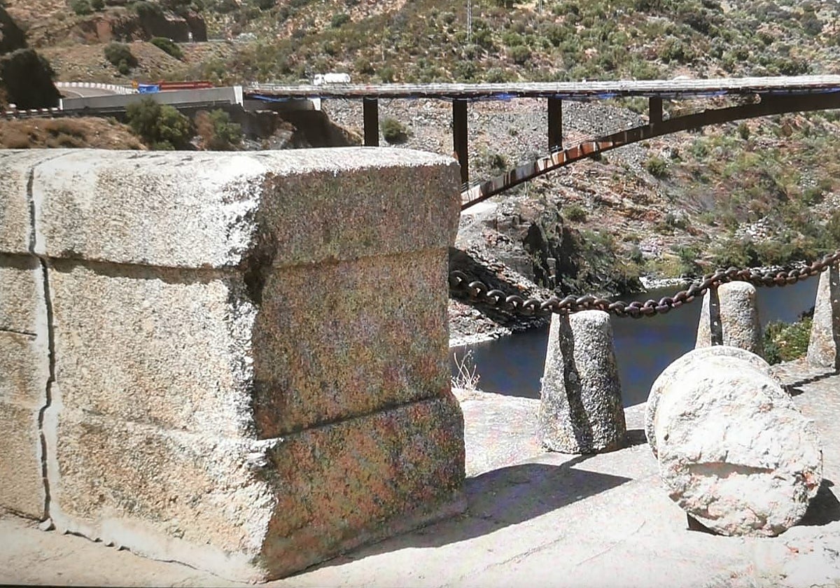 Puente romano de Alcántara rozado por un camión y a su lado la protección derribada. Al fondo, el nuevo puente, que permitirá dejar sin tráfico el romano a lo largo de este año.