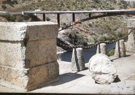 Puente romano de Alcántara rozado por un camión y a su lado la protección derribada. Al fondo, el nuevo puente, que permitirá dejar sin tráfico el romano a lo largo de este año.