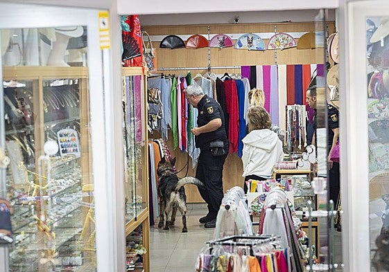 El equipo de guías caninos de la Policía Nacional registra la tienda.