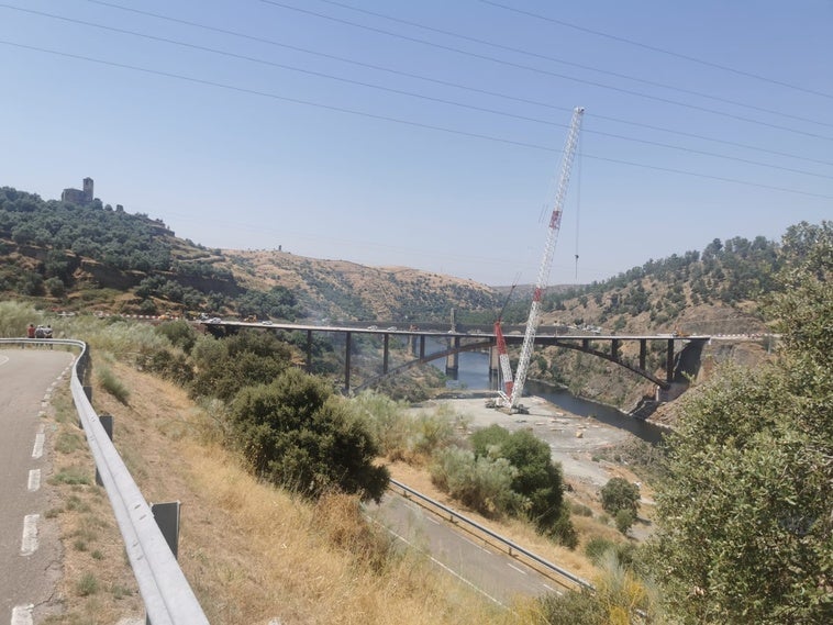 Los bomberos intentan apagar un incendio forestal entre los dos puentes de Alcántara