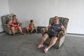 Adela Castaño junto a su hija y su nieto en el portal de su casa donde está instalada durante el día.