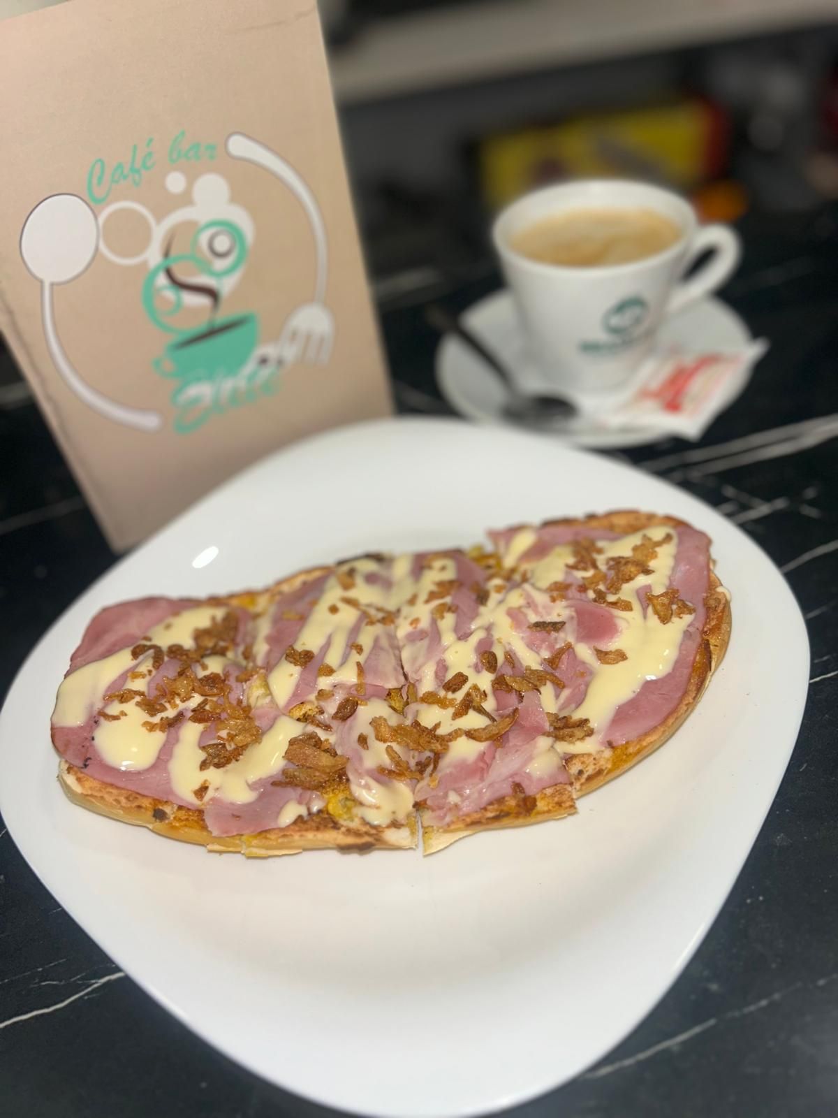 LaMorosa es una tostada realizada con pan artesano de Villafranco, con una suave base de mantequilla de Portugal, acompañada de Lacón, y coronada con queso gouda que le da ese toque de sabor extra junto con la cebolla crujiente. Una experiencia de sabores en la que todos los ingredientes hacen un equipo perfecto. Su nombre ha sido elegido por un grupo de clientes que llevan a nuestro lado desde hace muchos años y se merecían un espacio en la carta. También disponen de la opción sin gluten y siempre acompañado de su fantástico café